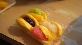 Thai vendor prepares colourful sticky rice sandwiches with durian and jackfruit slices as buns