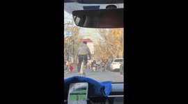 Young man drives modified tall bike on busy street in China