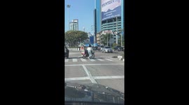 Kind girl helps to push disable man across road