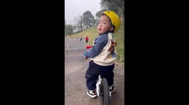Talented toddler rides bike at the park