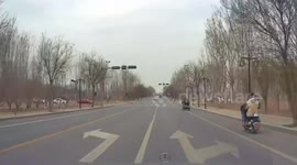 Fast-response elderly cyclist with grandson avoids colliding with oncoming vehicle at crossroad