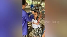 Mum curls daughter's hair using leaf stalks of cassava