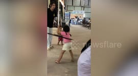 Little girl plays adorably with hula hoop