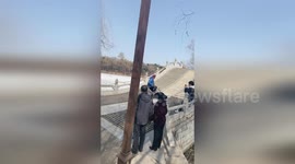 Skilled elderly cyclist stuns park visitors by riding backwards down bridge