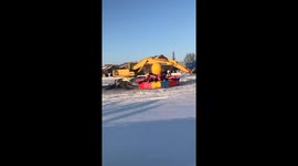 Giant excavator swings pendulum ride on ice in China