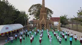 Buddhists pray and dance outside rice straw pagoda for Thai Songkran