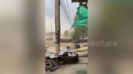 Wind gusts whip dust onto road as officials warn of summer storm in Thailand