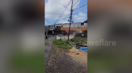 Minibus stuck on level crossing hit by train in Indonesia