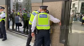 Police detain a man as thousands of pro-Palestine protesters march in central
