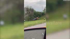 Good samaritans band together to overturn a flipped car and rescue woman trapped