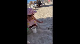 Little girl turns her mom's coffee cup into a sandbox