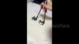 Chinese calligrapher demonstrates incredible skill by writing with two brushes simultaneously