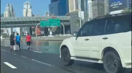 Stranded people walking on the highway in Dubai after the city got flooded by too much rain.