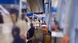 Commuters wade through flooded metro station in Dubai