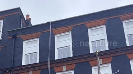 Rope Access Window Specialist Seen Clinging Over A Building During Inspection, Maintenance & Repairs