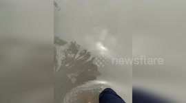 Dubai residents wade through flooded road after downpour