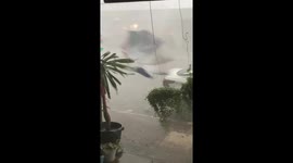 Hailstorm blows over woman in street in northern Thailand