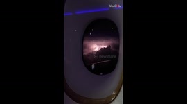 Emirates flight to Dubai encounters an electrifying light show over a storm-kissed night sky