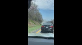 Quick-thinking driver hands fire extinguisher to burning car while still driving