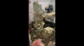 Women making camouflage nets in a cold premises of former factory building in Kyiv, Ukraine, giving operator a tutorial