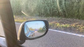 A fire engine responds to an accident on the M4 whilst passengers from cars caught in the tailback ply football on the slip road