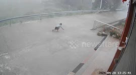 Chinese woman crawls along road after repeatedly being knocked down by gale-force winds