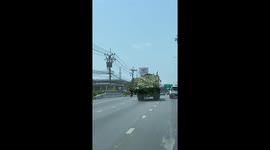 Driver clears fallen tree branches on busy road
