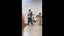 Awe-struck toddler watches busker in mall