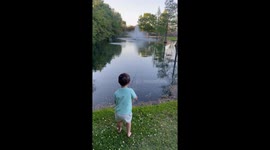 Little boy catches his first fish under his dad's guidance
