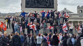St George's Day revellers sing and chant atop Nelson's Column