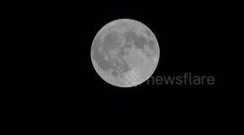 The April Full Moon known as the Pink Moon rises high in the sky over East London