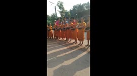 Young Buddhist monks chant outside home for morning donations