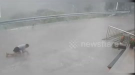 Young woman crawls through gale-force winds in China