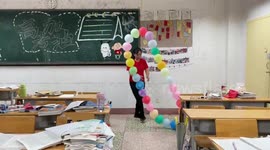 Teacher helps stressed pupils with rolling balloon ring in classroom