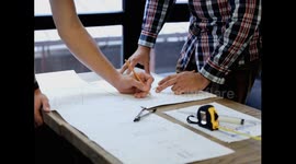Close-up of a man working on a project sketching architects on blueprints at a construction site. Architect, engineer concept in desk construction project banner close-up of drawing plans with archite