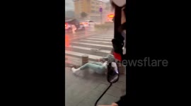 Chinese woman knocked down by fierce winds as city braces for rainstorm