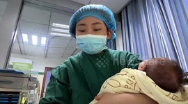 Multi-tasking nurse soothes baby while studying, turning medical knowledge into lullaby