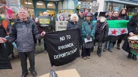 Protestors carry a coffin through town to mark 'death of compassion' following passing of Safety of Rwanda Bill