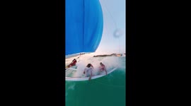 Waves hit holidaymakers in face while parasailing