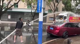 Man sprays truck with long hose for water fight for festival