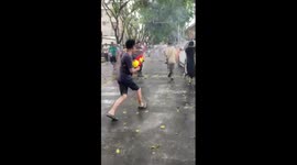 Tourist's slippers stuck to his ankle while spraying water at festival