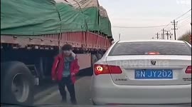 Daredevil boy risk lift to take shortcut beneath moving truck in China