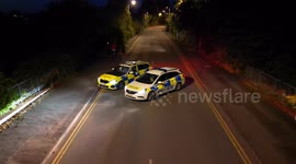 Two Wiltshire police officers blocking access to an industrial estate in Swindon, UK where an illegal car meet is taking place.