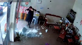 Glass door suddenly shatters as woman yawns and stretches beside it in southern China