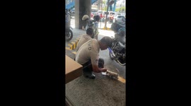 Kind traffic policeman feeds hungry stray kitten