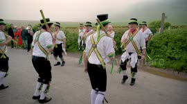Longman Morris Dancers perform below the Long Man of Wilmington, East Sussex, Britain