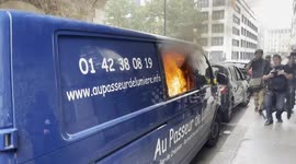 Anarchists and members of the press surround and film a van set on fire by protesters in Paris on May Day 2024