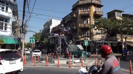 Optimus Prime watches over cars at roundabout in Bangkok