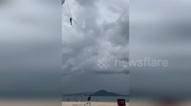 Crowd rushes in to stop parasail rider being blown out to sea