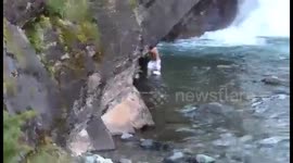 Man saves coyote after it fell off a waterfall into cold water